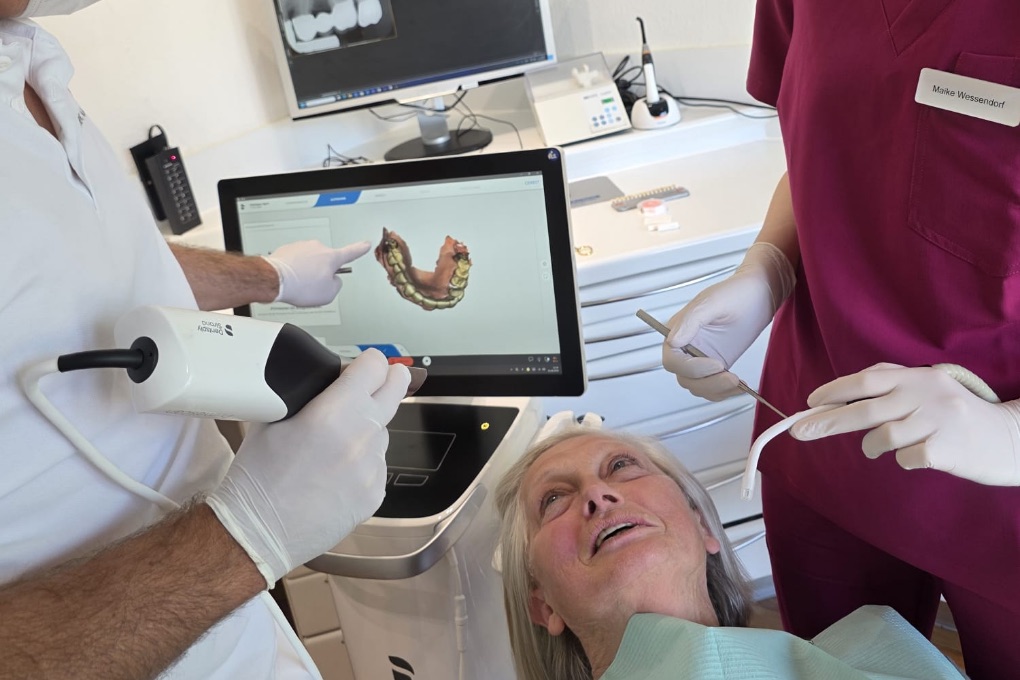 Digitaler Intraoralscan in der Zahnarztpraxis Rheine: der Zahnarzt zeigt der Patientin den 3D-Scan ihrer Zähne auf dem Bildschirm