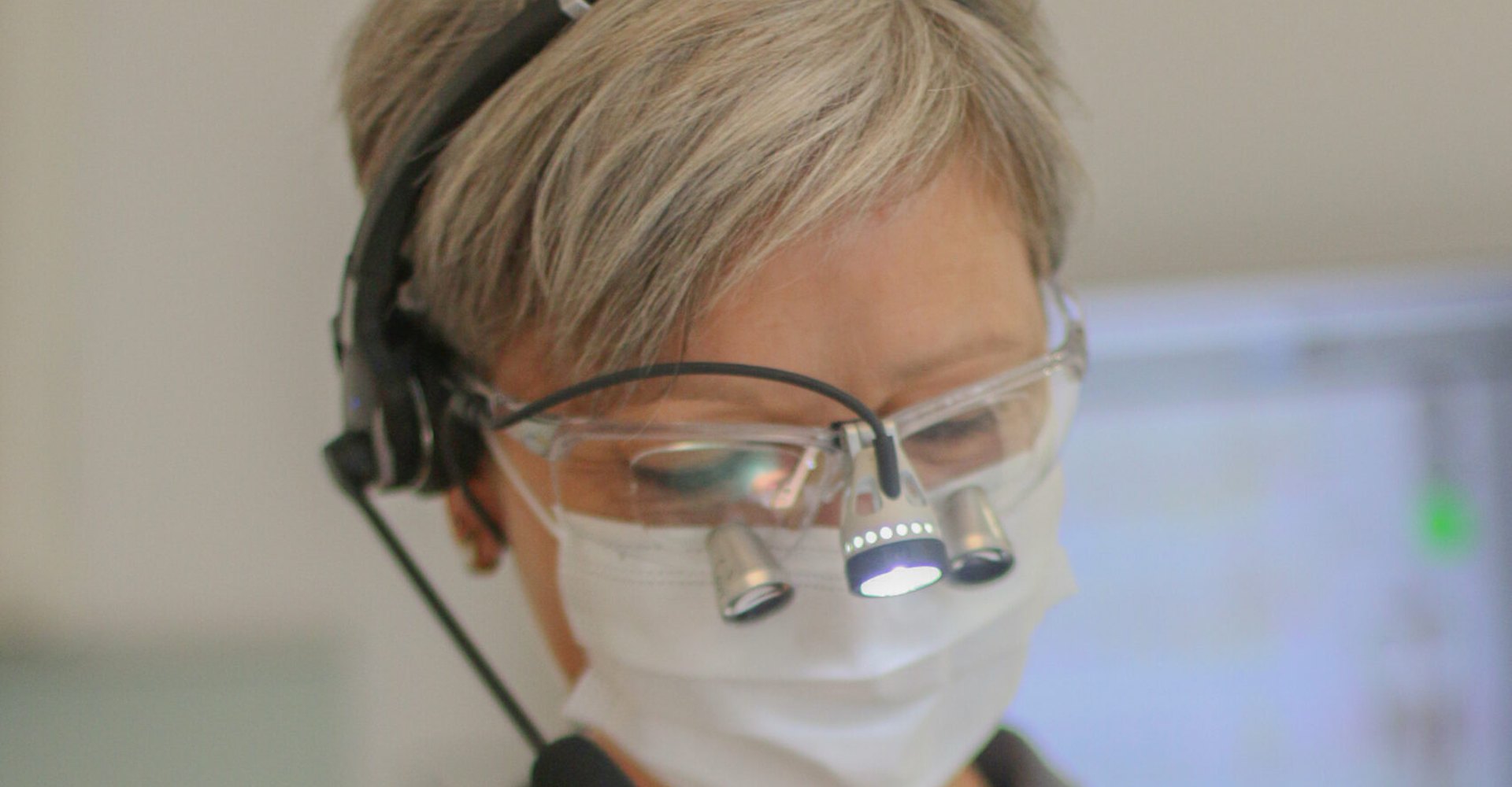 Prophylaxe-Mitarbeiterin mit Lupenbrille bei der professionellen Zahnreinigung in Rheine